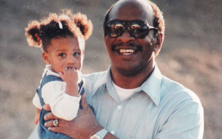 A grandpa holding his granddaughter and posing for a photo.